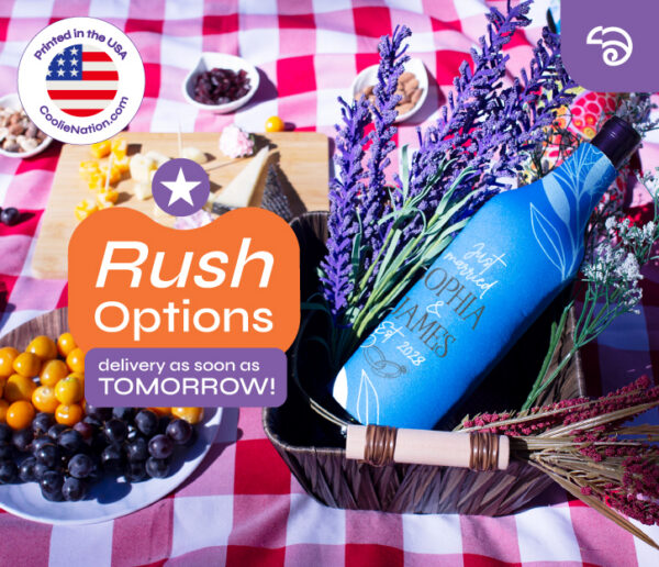 Blue personalized wine bottle cooler in picnic setting with grapes and flowers, featuring rush delivery options from CoolieNation.