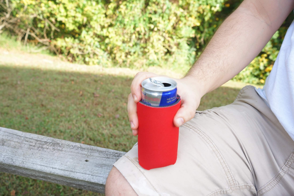 guy holding a blank koozie ready for customization