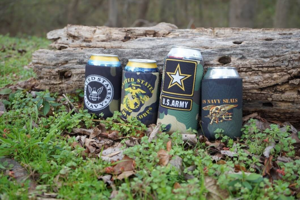 custom cans koozies with camo design in a row on the ground