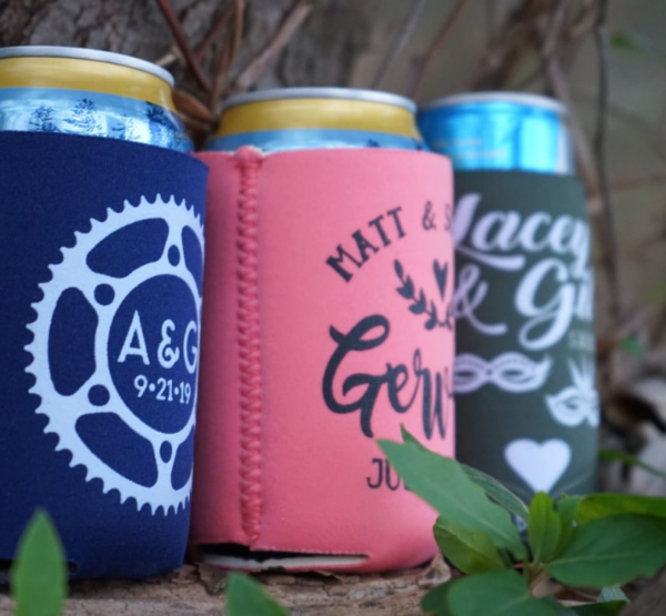 Three custom wedding koozies featuring the words "bike" and "heart" on them, perfect for keeping your drinks cool.