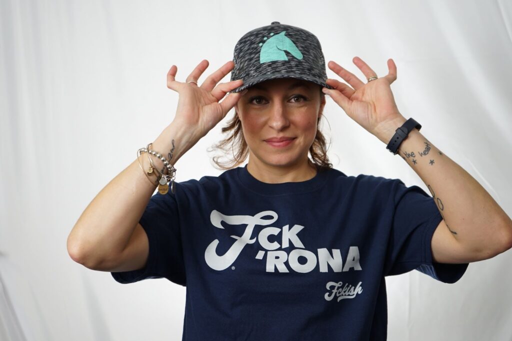 Woman posing with a custom t-shirt design and a chic ha