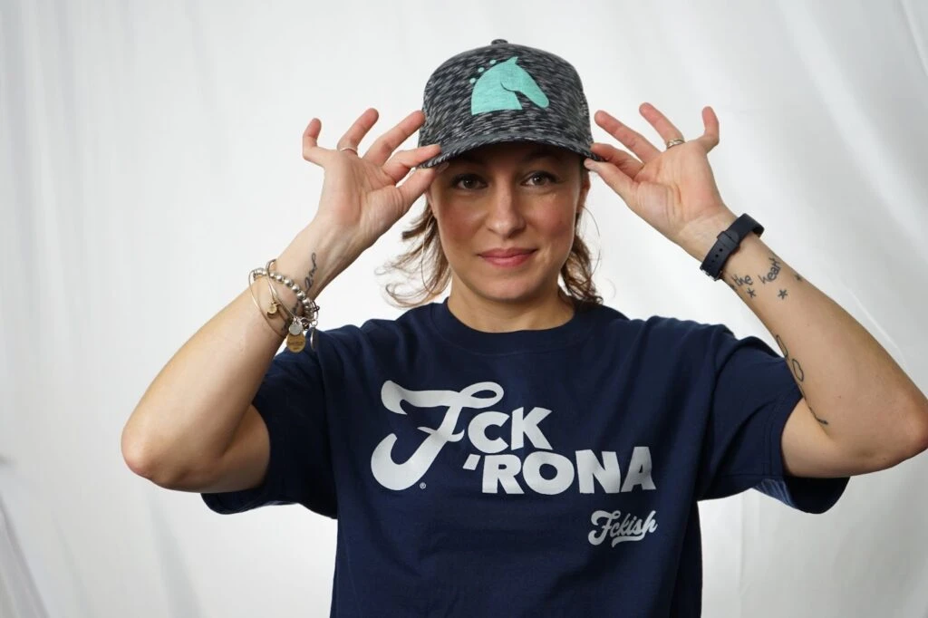 Woman posing with a custom t-shirt design and a chic ha